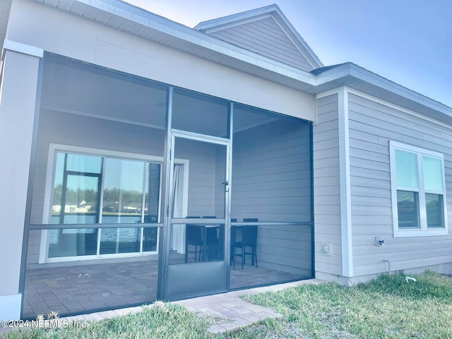 view of property exterior featuring a patio area and a sunroom