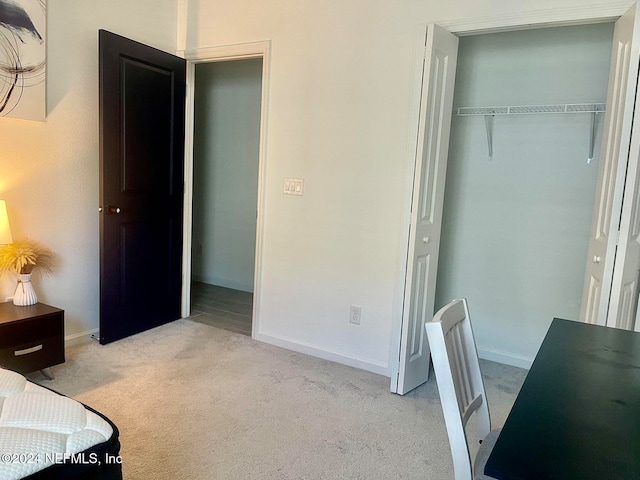 bedroom with light colored carpet and a closet