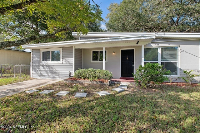 single story home with covered porch and a front yard