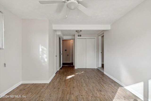 unfurnished bedroom featuring ceiling fan, wood-type flooring, a textured ceiling, and a closet