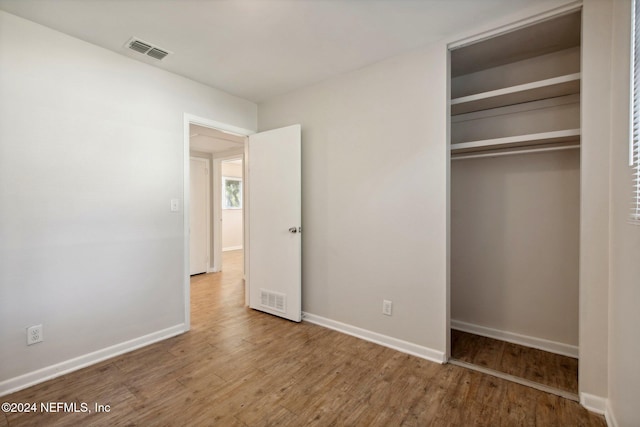 unfurnished bedroom with hardwood / wood-style flooring and a closet