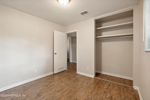 unfurnished bedroom with a closet and hardwood / wood-style floors