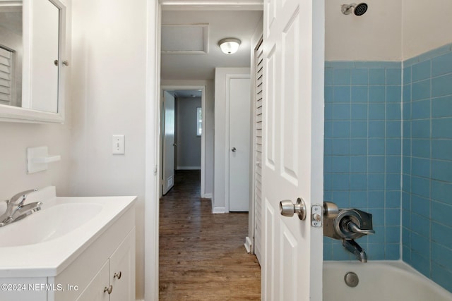 bathroom featuring vanity, tiled shower / bath, and wood-type flooring