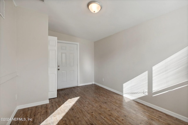 unfurnished room featuring lofted ceiling and dark hardwood / wood-style floors