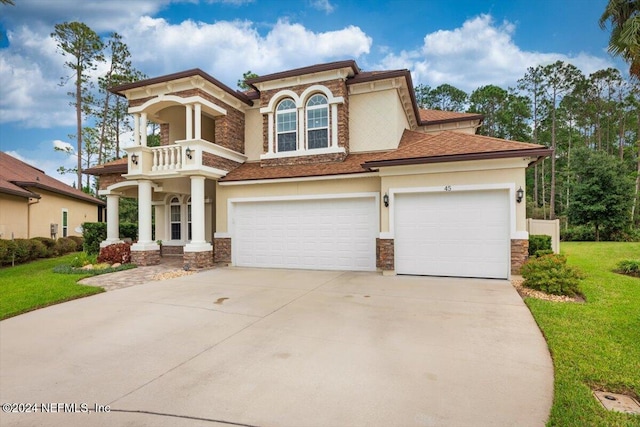 view of front of house with a front lawn, a garage, and a balcony