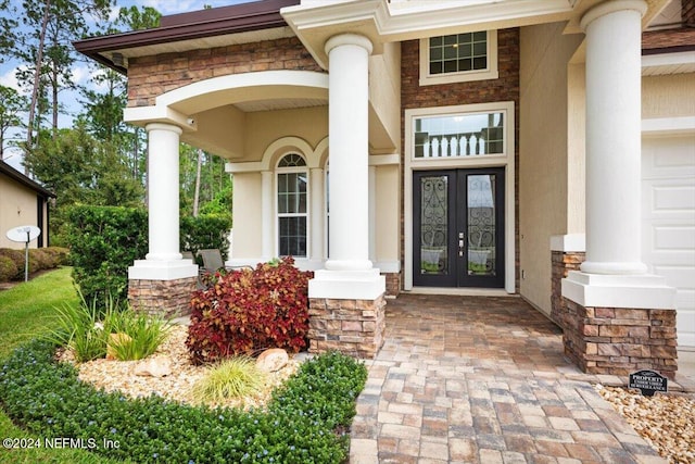 view of exterior entry with covered porch and a garage