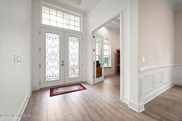 entryway featuring french doors, crown molding, and plenty of natural light