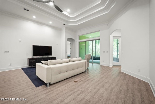 living room with light hardwood / wood-style floors, ornamental molding, and ceiling fan