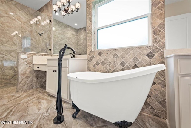 bathroom featuring vanity, tile walls, a chandelier, and a bath