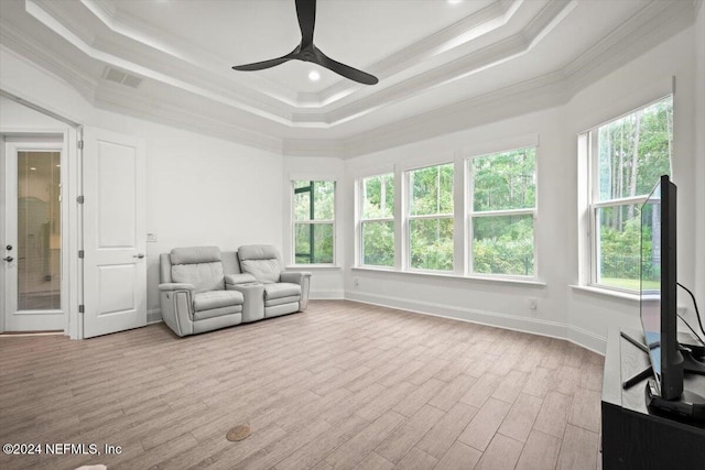 living area with crown molding, a tray ceiling, light hardwood / wood-style flooring, and ceiling fan