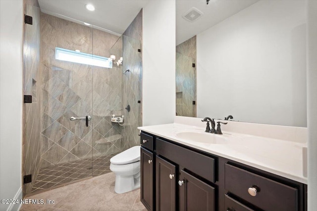 bathroom with vanity, toilet, tile patterned floors, and tiled shower