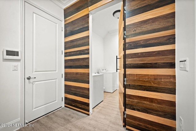 stairway featuring hardwood / wood-style floors, wooden walls, and independent washer and dryer