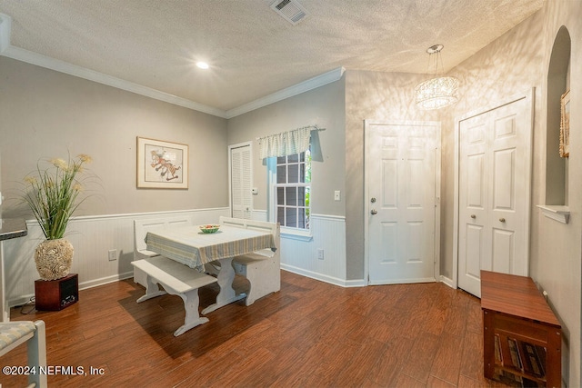 dining area featuring crown molding, a textured ceiling, and wood-type flooring