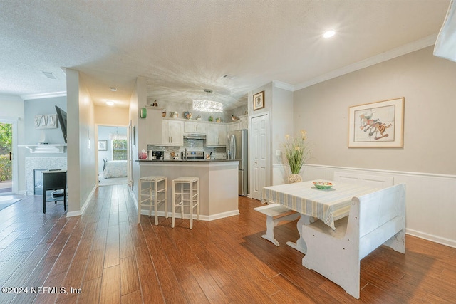 dining room featuring crown molding, hardwood / wood-style floors, and a wealth of natural light