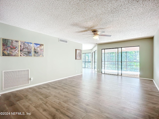 empty room featuring a textured ceiling, wood-type flooring, and ceiling fan