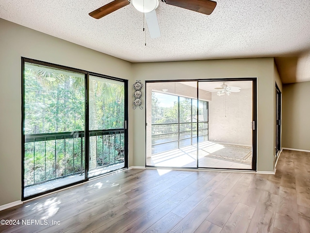 unfurnished room featuring a textured ceiling, light hardwood / wood-style floors, and ceiling fan