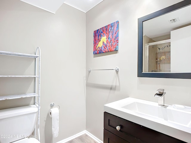 bathroom with a shower with door, hardwood / wood-style floors, toilet, vanity, and crown molding