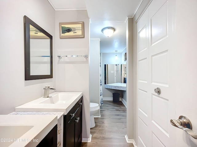 bathroom with vanity, ornamental molding, hardwood / wood-style flooring, and toilet