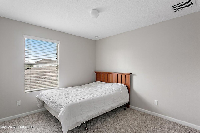 carpeted bedroom with a textured ceiling