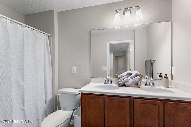 bathroom featuring vanity, toilet, a textured ceiling, and walk in shower