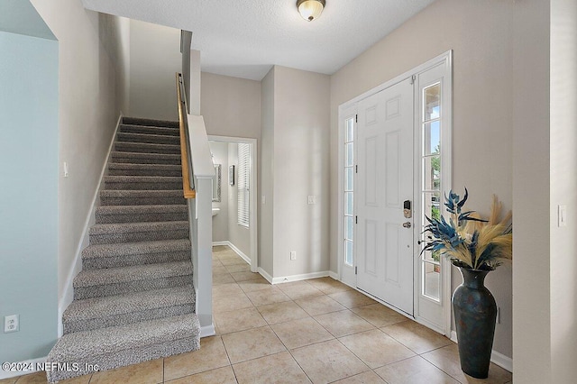 tiled foyer featuring a textured ceiling