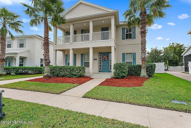 view of front of home with a front lawn and a balcony