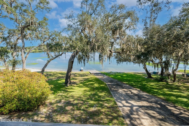 surrounding community with a lawn and a water view