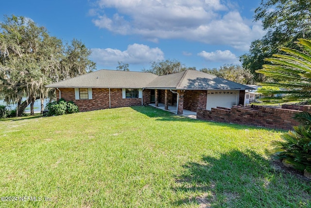 6706 Baja Ct, Keystone Heights, FL 32656 - back of property featuring a lawn, an attached garage, and brick siding