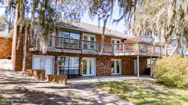 back of house with french doors and a yard