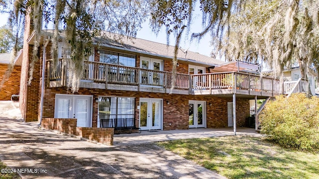 6706 Baja Ct, Keystone Heights, FL 32656 - back of property featuring a wooden deck, brick siding, a patio area, and french doors