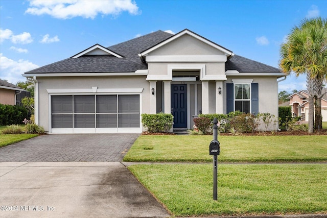 view of front of home with a front yard and a garage