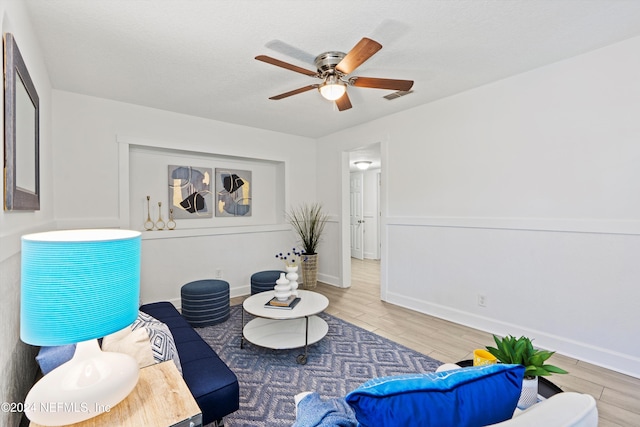 sitting room with hardwood / wood-style flooring and ceiling fan