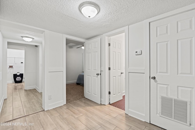 hall with a textured ceiling