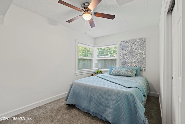 bedroom with a textured ceiling, carpet floors, and ceiling fan