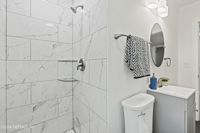 bathroom with vanity, toilet, and tiled shower