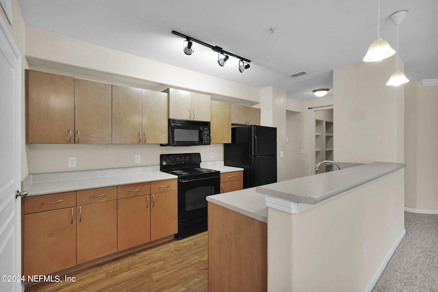 kitchen with sink, black appliances, pendant lighting, rail lighting, and light hardwood / wood-style floors