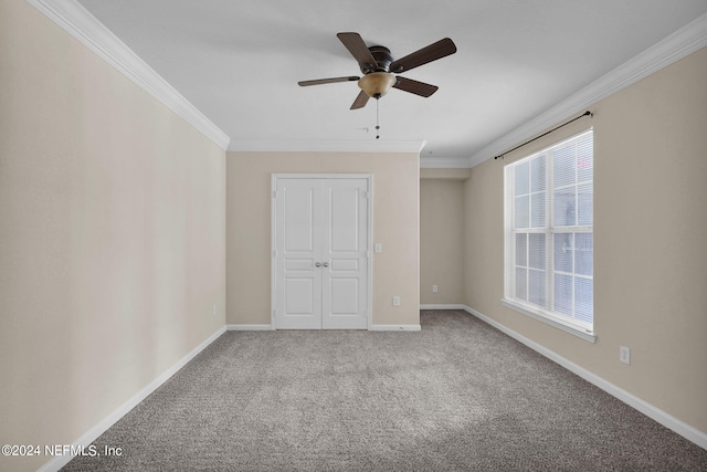 carpeted spare room featuring crown molding and ceiling fan