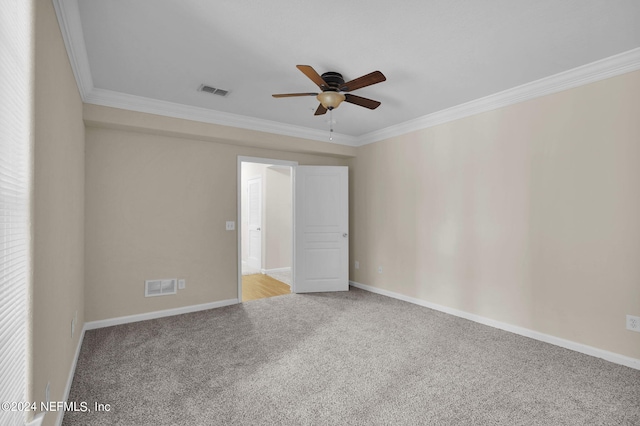 empty room featuring crown molding, carpet floors, and ceiling fan