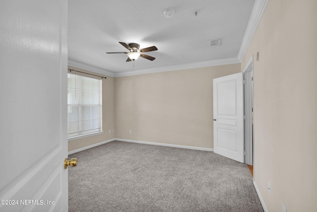 empty room featuring ceiling fan, ornamental molding, and carpet floors