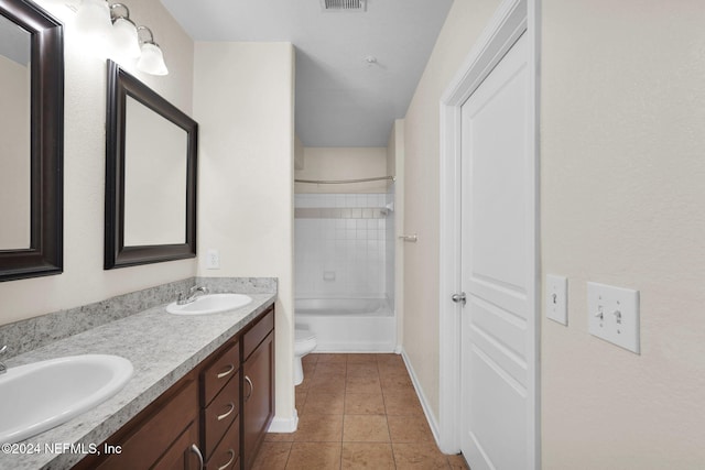 full bathroom featuring toilet, tiled shower / bath combo, vanity, and tile patterned flooring