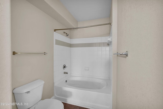 bathroom featuring tiled shower / bath combo and toilet