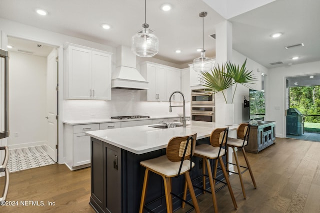 kitchen with custom exhaust hood, white cabinetry, stainless steel appliances, and dark wood-type flooring