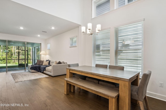 dining space with a notable chandelier and dark hardwood / wood-style flooring