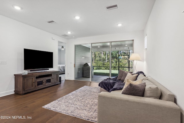 living room with dark hardwood / wood-style floors and ceiling fan