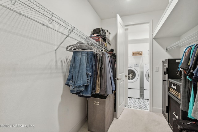 walk in closet featuring independent washer and dryer and carpet flooring