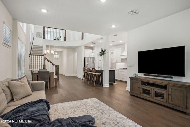 living room with dark hardwood / wood-style flooring and a chandelier