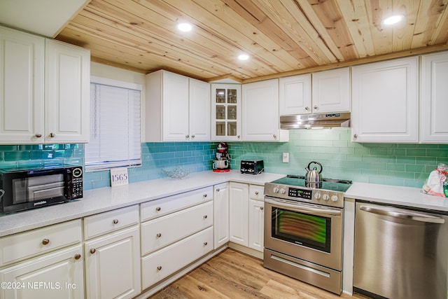 4 Ocean Trace Rd Unit 102, Saint Augustine, FL 32080 - kitchen with white cabinets, under cabinet range hood, stainless steel appliances, backsplash, and wood ceiling
