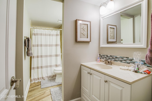 bathroom with decorative backsplash, toilet, a shower with curtain, wood-type flooring, and vanity