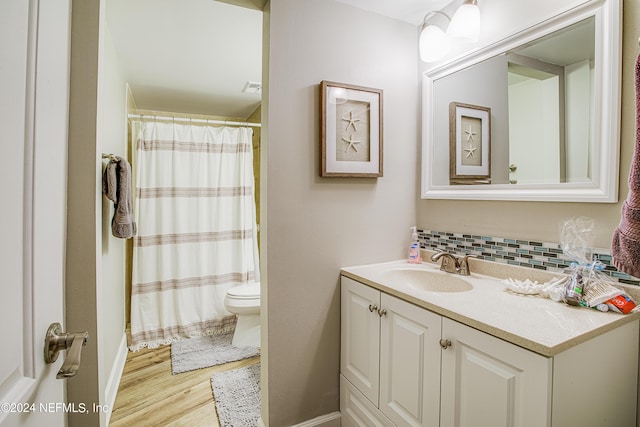 4 Ocean Trace Rd Unit 102, Saint Augustine, FL 32080 - full bath with tasteful backsplash, toilet, wood finished floors, curtained shower, and vanity