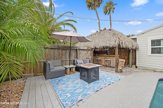 wooden deck featuring a patio area and an outdoor living space with a fire pit